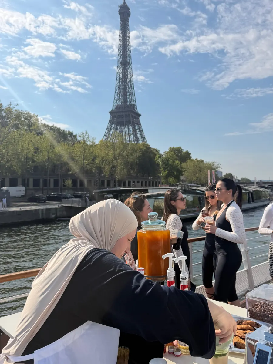 Notre barista prépare une boisson sur le pont, avec la Tour Eiffel en arrière-plan